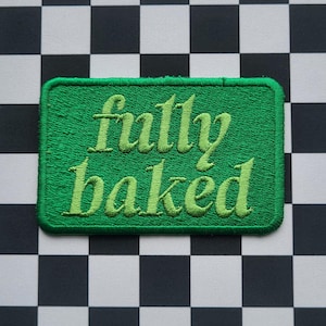 May include: Green embroidered patch with the text "fully baked" in a light green colour. The patch is on a black and white chequered background.