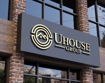 May include: A black sign with gold lettering and a gold logo of a house inside a circle. The sign reads "UHOUSE GROUP".