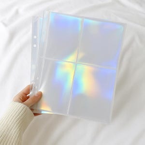 May include: Clear, iridescent trading card sleeves with six pockets per page. The sleeves are held by a three-hole punch binding. The light reflects a rainbow of colours across the clear plastic. The sleeves are designed to protect and display collectible cards.