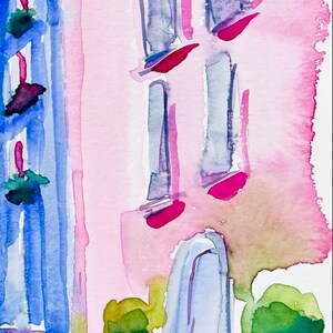 以下が含まれることがあります： ピンクの建物に青い窓と青いドアが描かれた水彩画。建物の前に、鉢植えの緑の茂みが2つある。