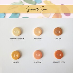 Puede incluir: Seis peque&ntilde;os c&iacute;rculos redondos de arcilla en tonos de amarillo, naranja y marr&oacute;n. Cada c&iacute;rculo tiene las letras "SH" en blanco en el centro. Los c&iacute;rculos est&aacute;n etiquetados como "Mellow Yellow", "Apricot", "Honey", "Mango", "Papaya" y "Orange Peel".