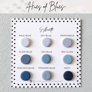 Pode incluir: Um cart&atilde;o branco com o texto "Hues of Blues" e "Sylhouette" impresso nele. O cart&atilde;o exibe nove pequenas amostras redondas de diferentes tons de tinta azul, etiquetadas com seus nomes: Azul claro, Azul c&eacute;u, Periwinkle, Azul ard&oacute;sia, Azul mar, Vidro do mar, Azul pav&atilde;o, Azul p&oacute; e Azul marinho.