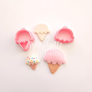 Puede incluir: Cortadores de galletas de plástico rosa con forma de cono de helado y un pequeño cono de helado con chispas. La imagen también incluye un cono de helado beige y un cono de helado rosa con una base de gofre. El texto "Sylhouette Studios" está en el centro.