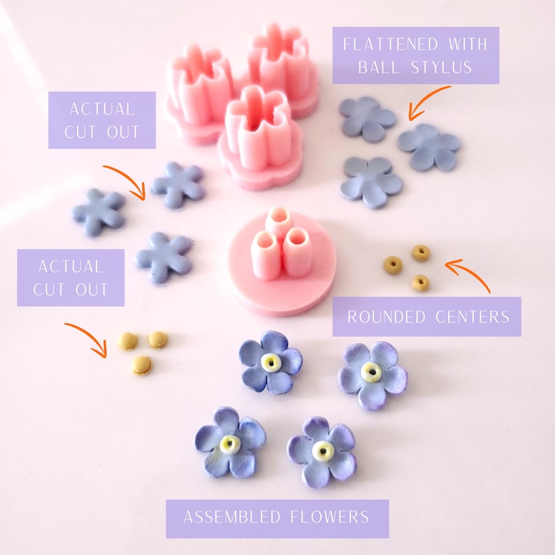 May include: A set of tools for making fondant flowers. The set includes a pink flower cutter, a pink tool for shaping the center of the flower, and three small, round, gold fondant pieces. There are also several finished fondant flowers in shades of purple and blue.