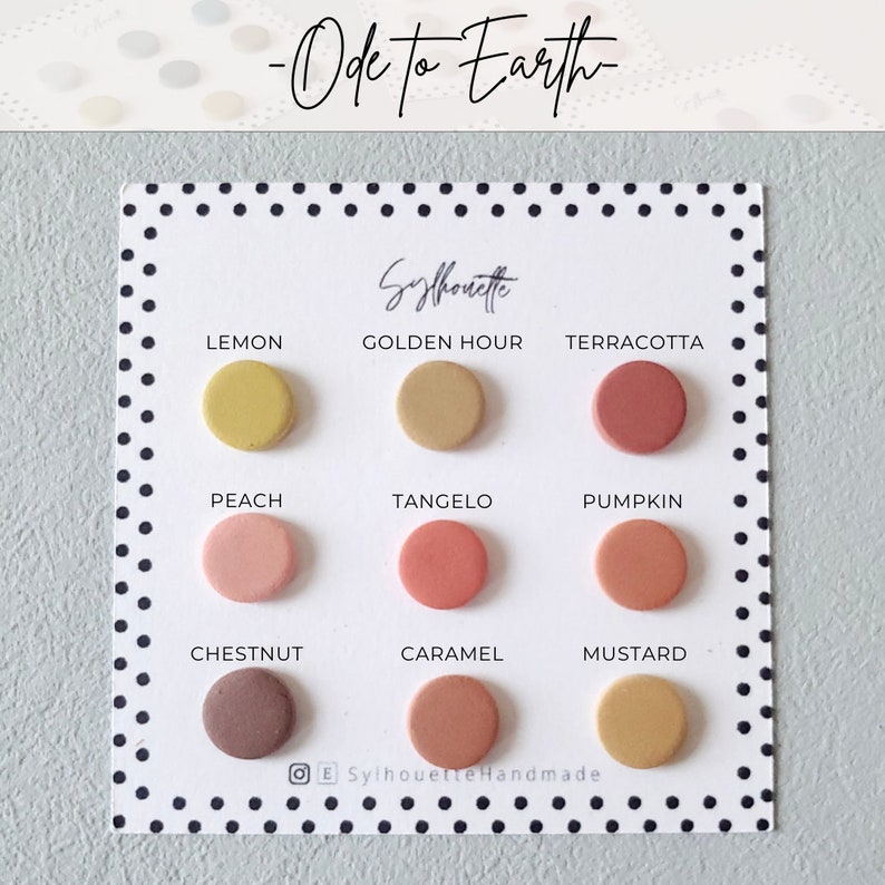 Pode incluir: Um cart&atilde;o branco com as palavras "Ode to Earth" e "Sylhouette" impressas nele. O cart&atilde;o mostra nove brincos redondos de argila em v&aacute;rios tons de marrom, laranja, amarelo e rosa. Cada brinco &eacute; etiquetado com um nome de cor, como "Lemon", "Golden Hour", "Terracotta", "Peach", "Tangelo", "Pumpkin", "Chestnut", "Caramel", e "Mustard".