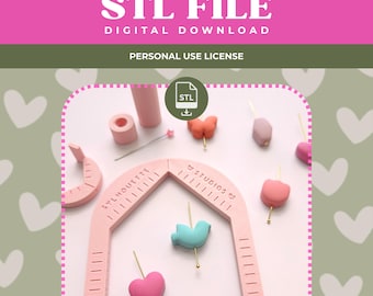 May include: A pink arch-shaped measuring tool with the text SYLMOUETTE STUDIOS and measurement markings, surrounded by various small colorful beads in shapes like hearts, a bird, and a butterfly, all on a light pink surface with an STL file icon.