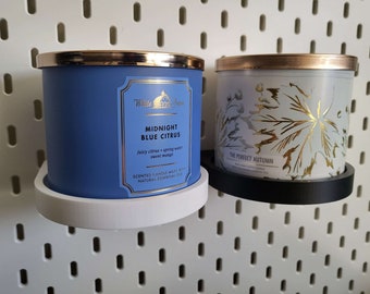 May include: Two scented candles in glass jars with metallic lids. One is navy blue with a label that reads "Midnight Blue Citrus." The other is white with gold leaf designs and the text "The Perfect Autumn."