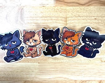 May include: Five stickers featuring cartoon cats with emo hairstyles, each with a broken heart and studded collar. The cats are in various colors: blue, brown, black, orange, and dark blue. They are sitting with arms crossed.