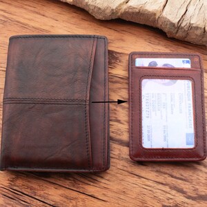 May include: A brown leather wallet with a separate card holder. The card holder has a clear window for displaying identification. The wallet has a stitched design and a flap closure.