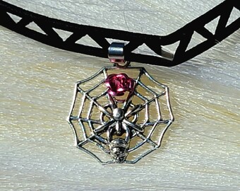 May include: Black choker necklace with a silver spider web pendant featuring a pink rose and a silver spider.