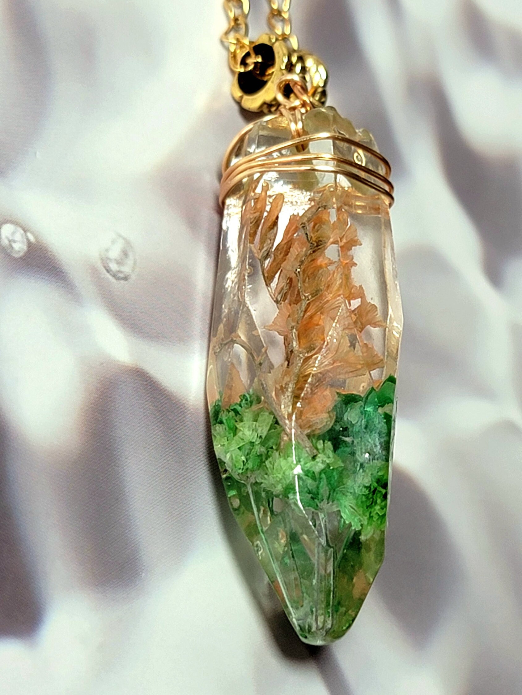 Pendentif circulaire cerclé de décor floral et végétal, goutte en chute