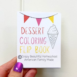 May include: A white coloring book with a black and white illustration of an ice cream cone. The title of the book is "Dessert Coloring Flip Book" with a banner of flags above the title. The copyright information is "&copy;Crazy Beautiful Homeschool American Family Made".