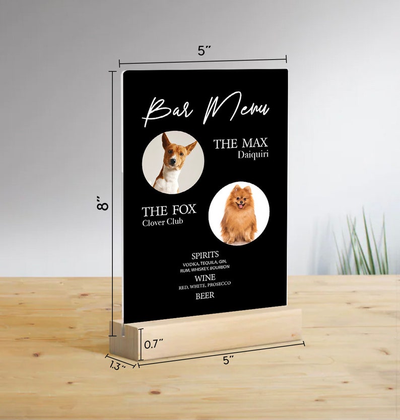 May include: Black acrylic sign with a wooden base, measuring 8 inches tall and 5 inches wide. The sign features a bar menu with two dog photos and the text "Bar Menu", "The Max Daiquiri", "The Fox Clover Club", "Spirits", "Vodka, Tequila, Gin, Rum, Whiskey, Bourbon", "Wine", "Red, White, Prosecco", and "Beer".