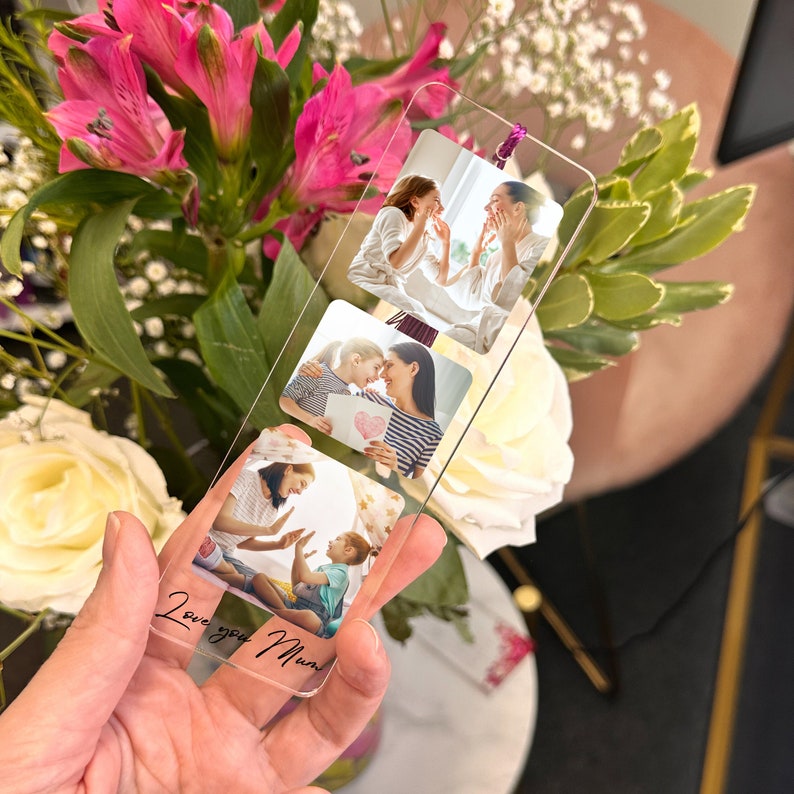 May include: A clear acrylic bookmark with three photos of a mother and child. The photos are arranged vertically and the bookmark has the text "Love you Mum" written on the bottom.