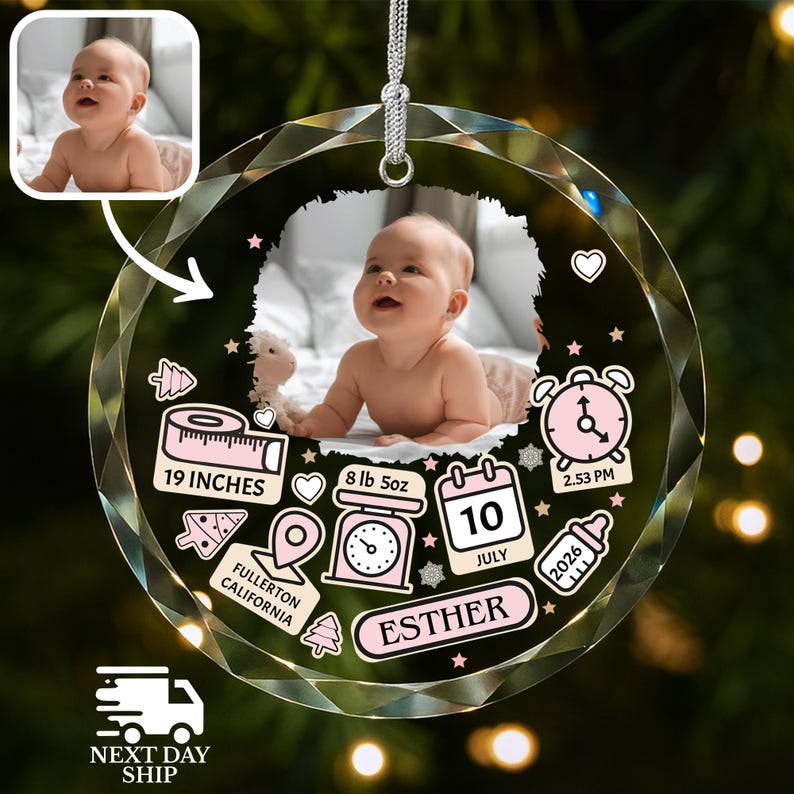 K&ouml;nnte beinhalten: Ein rundes, facettiertes Glasornament mit einem zentralen Babyfoto. Das Design enth&auml;lt rosa Grafiken: ein Ma&szlig;band mit der Aufschrift 19 INCHES, eine Waage mit 8 lb 5oz, einen Kalender mit 10 JULY, eine Uhr auf 2.53 PM und den Namen ESTHER.