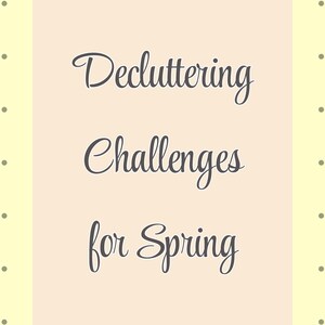 May include: A light yellow background with small gray dots surrounds a rectangular shape. The rectangle has a light peach color and contains the words "Decluttering Challenges for Spring" in a cursive font.