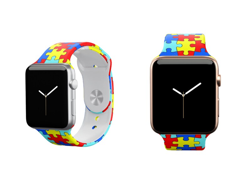 Puede incluir: Dos relojes Apple con correas de diferentes colores. Las correas son de silicona y presentan un patr&oacute;n de piezas de rompecabezas en azul, amarillo, rojo y blanco. El reloj de la izquierda tiene una caja plateada y el reloj de la derecha tiene una caja dorada.
