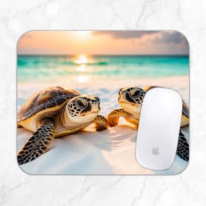 May include: A rectangular mousepad featuring two sea turtles on a sandy beach with turquoise water and a sunset in the background. A white computer mouse with an Apple logo is on the right side of the mousepad.