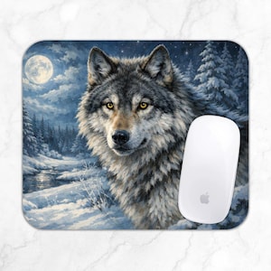 Könnte beinhalten: Ein rechteckiges Mauspad mit einer detaillierten Illustration eines grauen Wolfes mit bernsteinfarbenen Augen vor einer verschneiten Winterlandschaft mit Vollmond, Tannen und einem Bach, auf dem eine weiße kabellose Computermaus liegt.
