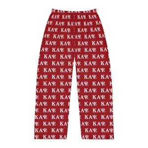 May include: Red pajama pants with a white repeating pattern of the Greek letters Kappa, Alpha, and Psi. The pajama pants are made of a soft material and have a relaxed fit.