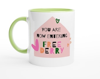 Ora stai entrando nella tazza in ceramica Free Derry Colorful Funky White da 11 once con interno verde