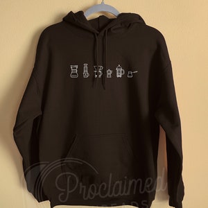 May include: Black hoodie with a white outline of different coffee brewing methods, including a pour over, French press, and a percolator.