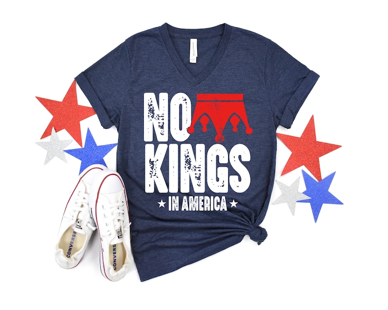 a navy blue t-shirt with the text "NO KINGS IN AMERICA" printed on it, along with a pair of white sneakers and red, white, and blue stars.