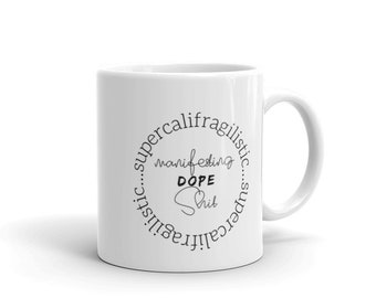 May include: White ceramic mug with a black circle design that says "supercalifragilisticexpialidocious...manifesting DOPE SH!T...supercalifragilisticexpialidocious"