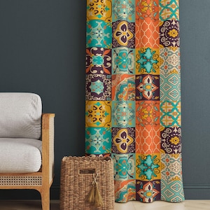May include: A patterned curtain with a patchwork design in shades of teal, orange, yellow, and purple. The curtain is next to a light gray sofa with a wooden frame and a woven basket with a tassel.