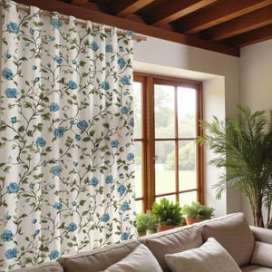 Könnte beinhalten: Cremefarbener Vorhang mit einem sich wiederholenden Muster aus blauen Rosen und grünen Blättern. Der Vorhang hängt vor einem Holzfenster, mit einem Blick auf eine grüne Wiese und Pflanzen. Der Vorhang ist an einer Holzstange befestigt.
