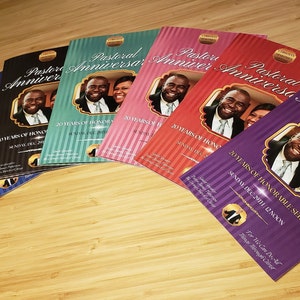 Puede incluir: Una pila de folletos de color morado, rojo, verde azulado, azul y gris con un borde dorado y una foto de una pareja en la portada. El texto en la portada de los folletos dice "Aniversario Pastoral" y "20 a&ntilde;os de servicio honorable".