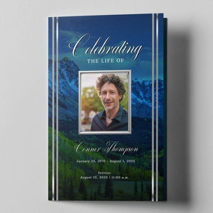Könnte beinhalten: Eine blaue und grüne Berglandschaft mit silbernem Rand. In der Mitte des Bildes befindet sich ein Foto eines Mannes. Unter dem Foto steht der Text "Celebrating the life of Conner Thompson". Unter dem Namen stehen die Daten "January 24, 1970 - August 1, 2024". Der Text "Service: August 10, 2024 | 11:00 a.m." befindet sich am unteren Rand des Bildes.