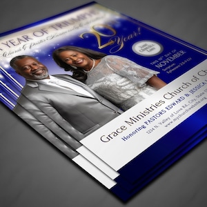 May include: A stack of flyers with a blue and white design. The flyers feature a photo of a smiling couple and text that reads "A Year of Triumph" and "Grace Ministries Church of Christ". The flyers are for an event honouring Pastors Edward & Jessica Love.