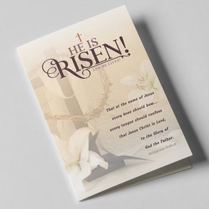 Könnte beinhalten: Eine gefaltete Osterkarte mit den Worten "HE IS RISEN!" in einer dekorativen Schriftart, zusammen mit dem Satz "AND HE LIVES!" und einem Bibelvers. Die Karte zeigt ein Kreuz, eine Dornenkrone und weiße Lilien.