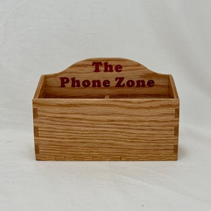 May include: A wooden phone holder with the words "The Phone Zone" in red lettering on the front.