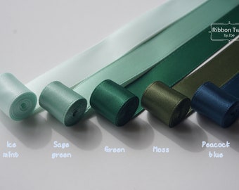 May include: Five spools of satin ribbon in shades of green and blue. The colors are ice mint, sage green, green, moss, and peacock blue. The ribbon is labeled "Ribbon Twist by Zoe".