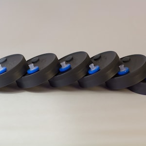 May include: Six black plastic lids with a blue and clear plastic insert in the center of each lid.