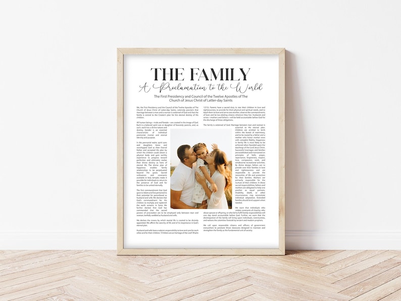Pode incluir: Uma impress&atilde;o emoldurada com o texto "THE FAMILY A Proclamation to the World" e uma foto de fam&iacute;lia. A impress&atilde;o est&aacute; em uma moldura de madeira de cor clara e &eacute; exibida contra uma parede branca.