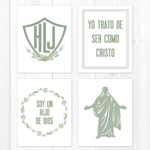 May include: Four framed art prints with a white background and sage green designs. One print features initials inside a shield, another reads "YO TRATO DE SER COMO CRISTO", a third says "SOY UN HIJO DE DIOS", and the last depicts a figure with outstretched arms.