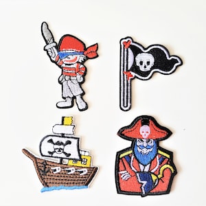 Peut inclure: Quatre patchs brodés thermocollants représentant un bateau pirate, un pirate avec une barbe et un cache-œil, un pirate avec une épée et un drapeau pirate noir avec un crâne et des os croisés.
