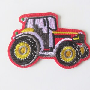 Peut inclure: Patch thermocollant brodé représentant un tracteur rouge, noir et jaune.