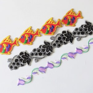 以下が含まれることがあります： カラフルな刺繍の魚のパッチ4つ、黒い刺繍のブドウのつるのパッチ、紫と緑の刺繍の花のつるのパッチのセットです。