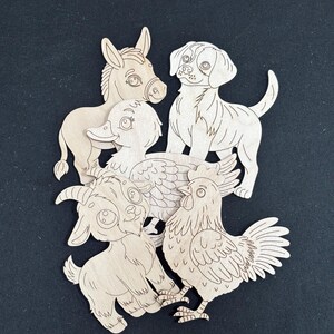 May include: A collection of five light-colored wooden cutouts featuring cartoon-style animals including a donkey, a dog, a duck, a goat, and a rooster. Each piece displays engraved outlines of the animal's features, such as eyes, fur, and feathers.
