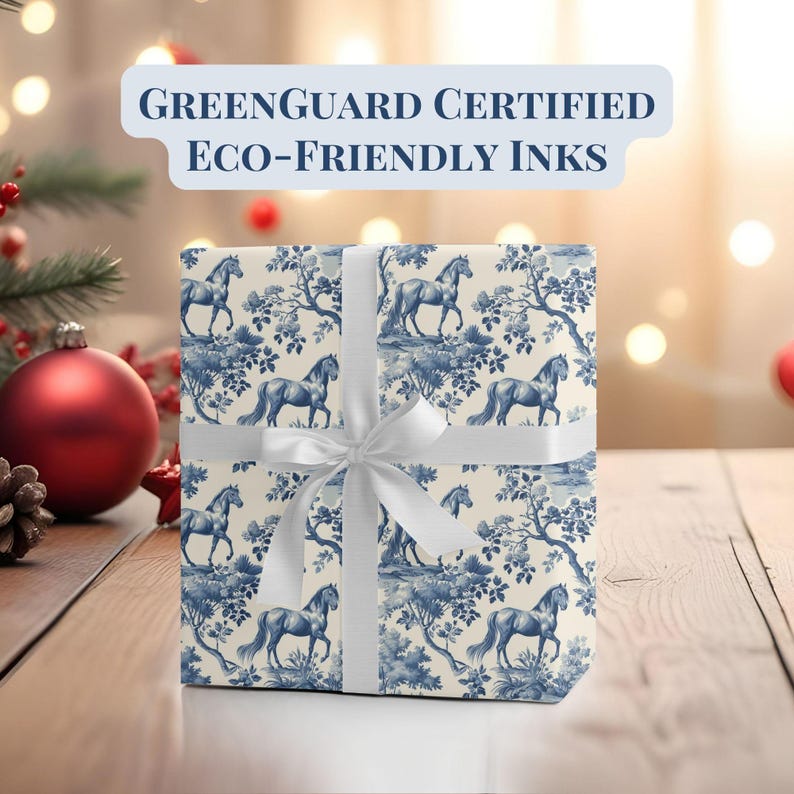 May include: A white gift box with a blue and white horse pattern. The box is tied with a white ribbon and has a "GREENGUARD CERTIFIED ECO-FRIENDLY INKS" label.