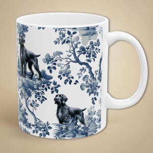 Peut inclure: Mug en céramique blanche orné d'un motif toile de Jouy bleu et blanc représentant des chiens, des fleurs et des arbres. La tasse a une anse incurvée et une finition lisse. Idéale pour le thé ou le café.