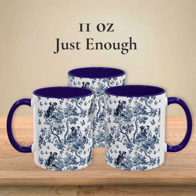 May include: Three 11 ounce ceramic mugs with a blue and white floral pattern featuring a bulldog design. The mugs have a blue rim and handle.