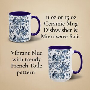 May include: A white ceramic mug with a vibrant blue rim and handle. The mug features a blue and white toile pattern with a repeating design of stylised dogs and butterflies. The text "II oz or 15 oz Ceramic Mug Dishwasher & Microwave Safe" is printed in black on a white background.