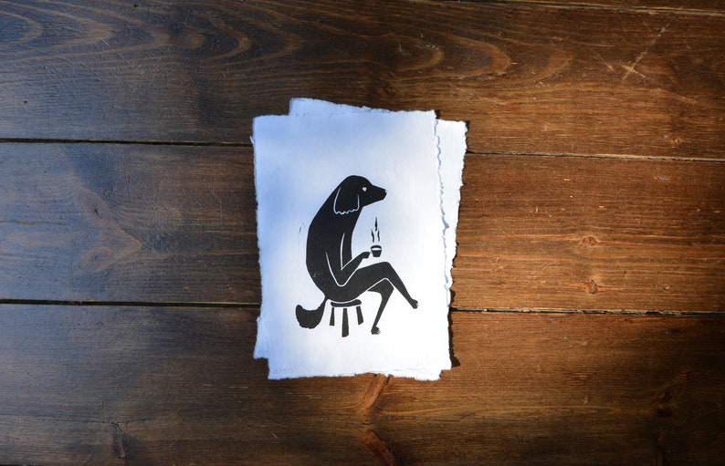 May include: Black and white illustration of a dog sitting on a stool and holding a cup of coffee.