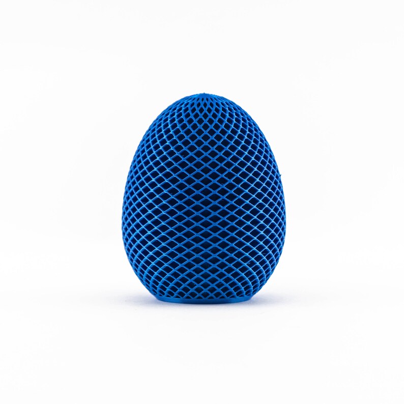 May include: A blue egg-shaped object with a geometric pattern. The object is made of a material that appears to be plastic or rubber.