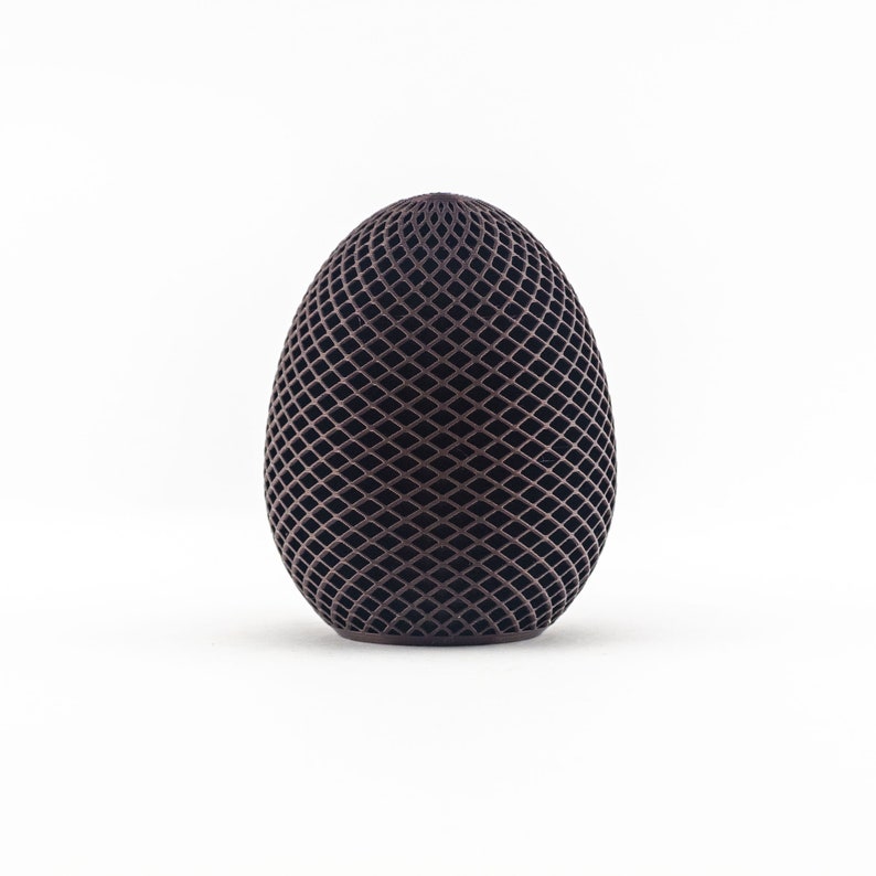 May include: A dark brown egg-shaped object with a geometric pattern of intersecting lines.